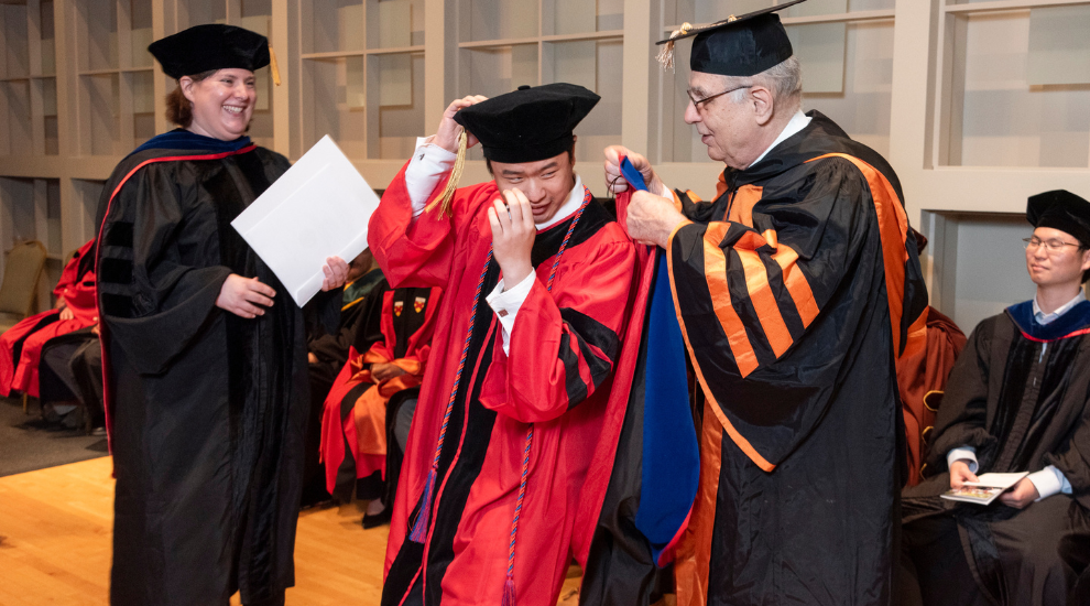 student and faculty members dressed in regalia during commencement